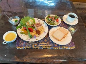 a table with plates of food and cups of coffee at 八ヶ岳高原テラス Space Hotel the amulapo in Hara