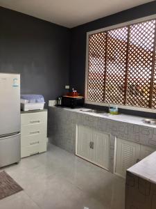 Ban Tha Nam Tun的住宿－Walai House วลัยเฮ้าส์ กาญจนบุรี，厨房配有白色橱柜和白色冰箱。