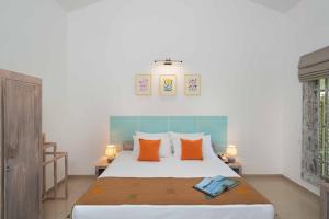 1 dormitorio con 1 cama grande con almohadas de color naranja en Palmera Eco Resorts Nilaveli en Trincomalee