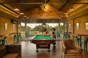 two people playing pool in a room with a pool table at Palmera Eco Resorts Nilaveli in Trincomalee
