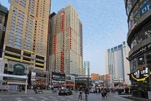 a city with tall buildings and a street with people at RUNA Stay HAEUNDAE in Busan