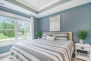 a blue bedroom with a bed and a window at The Heron House-On The Lake! in Wolcottville