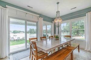 a dining room with a table and chairs and windows at The Heron House-On The Lake! in Wolcottville