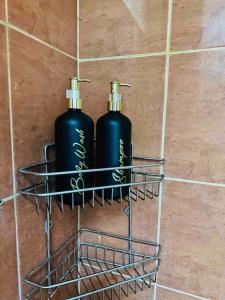 two black bottles in a wire rack on the floor at Cc homestay dekat Malioboro in Kejayan