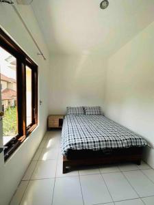 a bedroom with a bed in a room with a window at Cc homestay dekat Malioboro in Kejayan