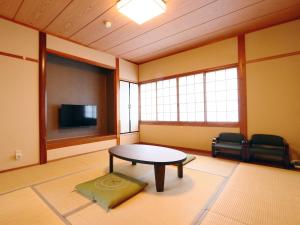 a room with a table and a flat screen tv at Kii no Matsushima in Kihokucho