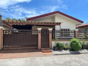 une maison avec une porte en bois et une clôture dans l'établissement Mi Casa Gensan - Beautiful 2BR house with wifi & netflix, à General Santos