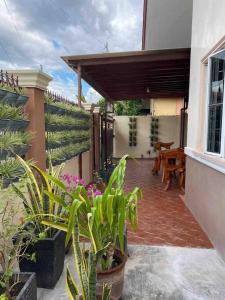 ein Haus mit einer Terrasse mit Pflanzen und einem Tisch in der Unterkunft Mi Casa Gensan - Beautiful 2BR house with wifi & netflix in General Santos