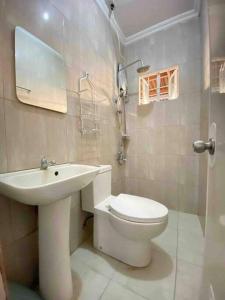 a bathroom with a toilet and a sink at Mi Casa Gensan - Beautiful 2BR house with wifi & netflix in General Santos