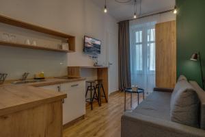 uma cozinha e uma sala de estar com um sofá num quarto em Apartamenty Centrum Dworzec PKP self check-in 24h em Katowice