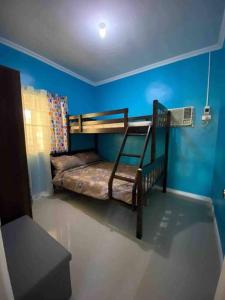 ein Schlafzimmer mit einem Etagenbett in einem blauen Zimmer in der Unterkunft Mi Casa Gensan - Beautiful 2BR house with wifi & netflix in General Santos