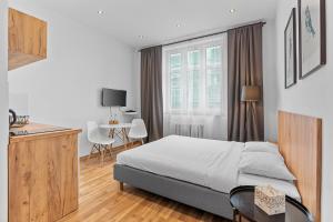 a bedroom with a bed and a table and a window at Apartamenty Centrum Zameldowanie 24h in Katowice +13 photos