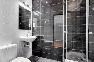 a black and white bathroom with a toilet and a sink at Apartamenty Centrum Zameldowanie 24h in Katowice