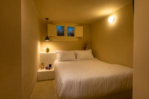 a small bedroom with a bed and a window at RockHill Luxury Suite Imerovigli in Fira