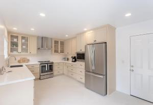 a kitchen with white cabinets and a stainless steel refrigerator at 3896 Gather and Rest home in Del Rey Oaks