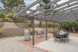 a patio with a table and chairs under a pergola at 3896 Gather and Rest home in Del Rey Oaks