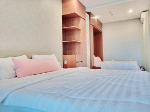 um quarto com 2 camas e uma almofada cor-de-rosa em CĂN HỘ 5 SAO THE SÓNG VŨNG TÀU- CONDOTEL 5 STAR THE SÓNG APARTMENT Mr VƯƠNG. em Vung Tau