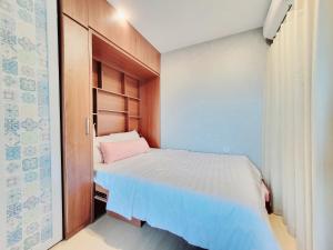 um pequeno quarto com uma cama com uma almofada rosa em CĂN HỘ 5 SAO THE SÓNG VŨNG TÀU- CONDOTEL 5 STAR THE SÓNG APARTMENT Mr VƯƠNG. em Vung Tau