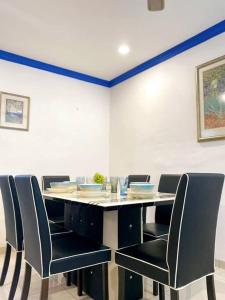 une salle à manger avec une table et des chaises noires dans l'établissement (TN)Modern Stylish 2 Storey Corner House @Alma BM, à Bukit Mertajam