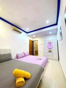- une chambre avec un lit et une serviette jaune dans l'établissement (TN)Modern Stylish 2 Storey Corner House @Alma BM, à Bukit Mertajam