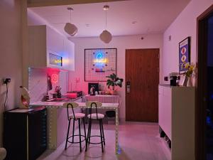 uma cozinha com paredes cor-de-rosa e um balcão com bancos em MADLAD SPACE homestay em Kinh Dinh