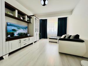 Una sala de estar con un sofá y un televisor. en Altheda Living Welcome Home, en Suceava