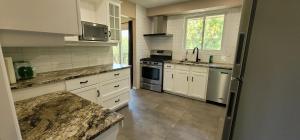 a kitchen with white cabinets and marble counter tops at Niagara Falls Villa with Private pool, hottub, water view and Breakfast in Niagara Falls