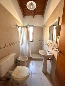 a bathroom with a toilet and a sink and a toilet istg at Cabañas El Francés in Merlo