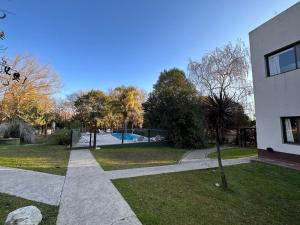 a walkway leading to a park with a swimming pool at Cabañas El Francés in Merlo