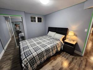 a bedroom with a bed and a person taking a picture at Adorable 2-Bedoom walkout basement Apartment in Milton