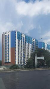 ein großes Gebäude an der Straßenseite in der Unterkunft Ашык Тобе in Almaty