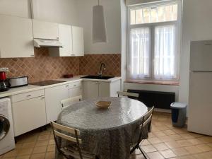 a kitchen with a table and chairs in a kitchen at La Célestine in Valensole