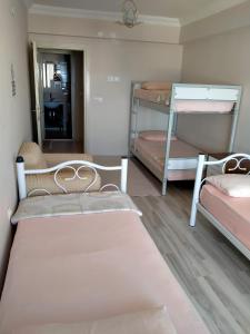Gerze Apart Otel في غرزي: غرفة بها ثلاثة أسرة بطابقين ومرآة