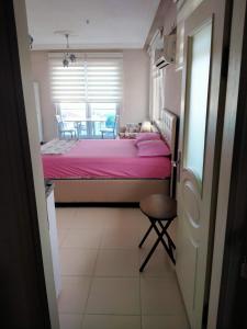Gerze Apart Otel في غرزي: غرفة نوم مع سرير وملاءات وردية وطاولة