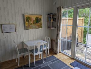 ein Esszimmer mit einem Tisch, Stühlen und einem Fenster in der Unterkunft Cute little cottage in Höllviken in Höllviken