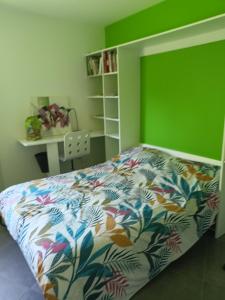 Mayeux في Nances: غرفة نوم بسرير وجدار أخضر