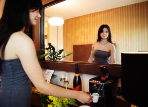 a woman is standing in front of a mirror at Hotel Centrum in Nitra