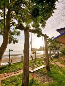 a swing hanging between two trees on the beach at Janpa Resort in Don Sak