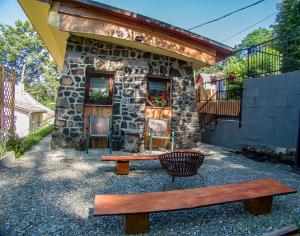 a stone building with a bench in front of it at Larix Mátra Vendégház in Matraszentlaszlo