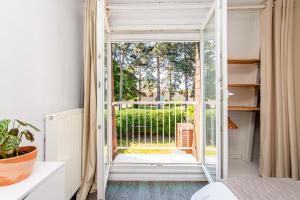 1 dormitorio con puerta abierta a un balcón en La Maison des Sourires - Parking gratuit - Jardin - Jeux enfant babyfoot, pingpong - Proche Parc Astérix, Aéroport Charles de Gaulles, Mer des sables, Chantilly, en Fosses