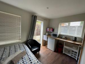 um quarto com uma cama, uma secretária e uma cadeira em Studio-2 Staines,Heathrow, London-own entrance em Staines