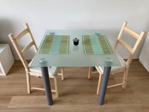 una mesa azul con dos sillas y una taza en ella en Über den Dächern von Offenbach, en Offenbach