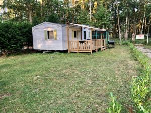 uma pequena casa sentada num quintal num campo em Camping Parc des Roches-Mobilhome em Saint-Chéron