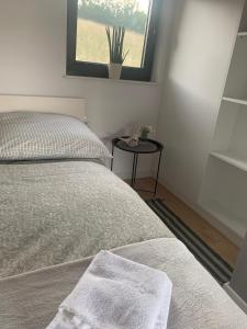 1 dormitorio con 1 cama y 1 mesa con ventana en RUBIESZCZA domek z widokiem na jezioro, en Wołkowyja