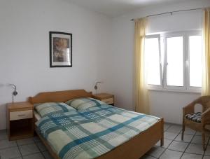 ein Schlafzimmer mit einem Bett, einem Stuhl und einem Fenster in der Unterkunft Casa Svjetlana in Orebić