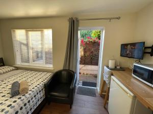 1 dormitorio con cama, escritorio y ventana en Studio-2 Staines,Heathrow, London-own entrance en Staines