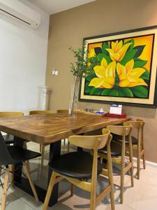 a dining room table and chairs with a painting on the wall at Timurahaus in Kajang