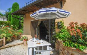 a table and chairs under an umbrella on a patio at Amazing Apartment In Monte Rinaldo in Monte Rinaldo