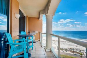 d'un balcon avec des chaises bleues, une table et l'océan. dans l'établissement Portofino Island Resort P5-1003, à Pensacola Beach