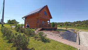 mały drewniany dom na trawiastym polu w obiekcie Leśny Zakątek Radocza w mieście Radocza